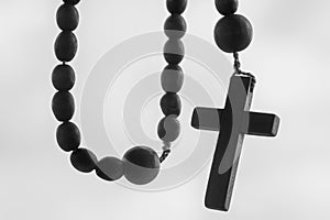 Close up rosary beads against white background. Selactive focus on cross. Christianity, religion, faith concept