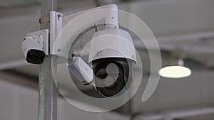 Close-up rotating black surveillance control camera indoors.