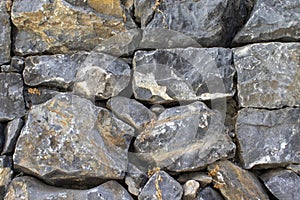 Close-up of rough weathered stone wall texture, full frame background