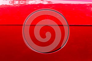 Close-up of the round fuel tank cap of a red car