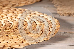 Close-up of round wicker placemat of rattan on wooden table for dining decor