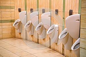 Close up row of urinals men public toilet