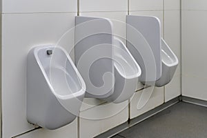 Close up row of urinals men public toilet