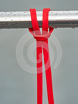 Close-up of a rubber elastic band training knot hanging on a workout crossbar photo