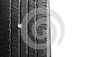 Close up of rubber tires leak, automobile tire drilled with a metal screw nail, isolated on white background