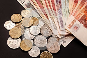 Close-up of rubles coins of different value and a stack of banknotes