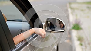 Close-up of a rude boy throws trash out the car window onto the road.