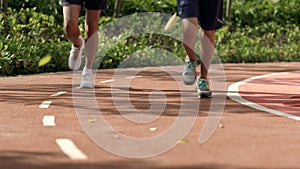 Close up of running feet on red track in the morning in slow motion