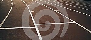 Close-up of a running track in a stadium with white striped markings.