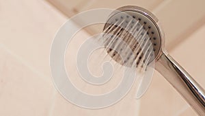 Close-up running water shower head with turning on and off in bathroom.