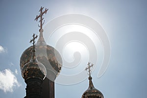 Close-up.Russian Christian Orthodox Church with domes and a cross on the background of the sky with the sun.Concept of