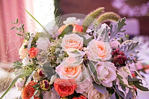 Close up rustic flower arrangement with beige roses at a wedding banquet. Roses