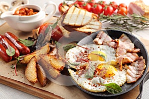 Close up of rustic full english breakfast on a white wooden table