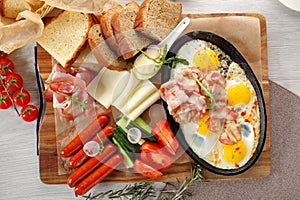 Close up of rustic full english breakfast on a white wooden table