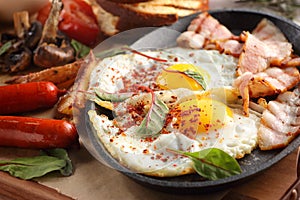 Close up of rustic full english breakfast on a white wooden table