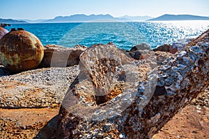 Close-up of a rusty anchor on the shore at Aegina harbour in Greece