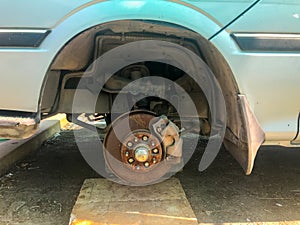 Rusty broken car with missing wheel