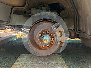 rusty broken car with missing wheel