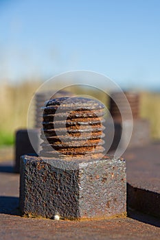 Close-up of rusty brown bolts on the background the sky