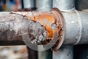 close-up of rusty downpipe being replaced with new galvanized steel pipe