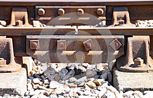 Close up of rusty railway track showing the nuts and bolts of the fishplate which joins sections of track
