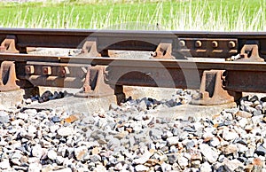 Close up of rusty railway track showing the nuts and bolts of the fishplate which joins sections of track