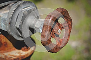 Close-up of a rusty tap valve on an old water pump.