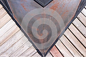 Rusty triangle metal texture with old weathered wood diagonal patterns on wall light brown background