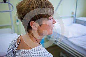 Close-up of sad senior patient sitting on a bed