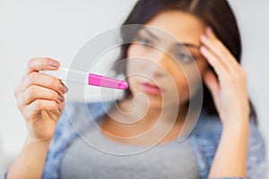 Close up of sad woman with home pregnancy test