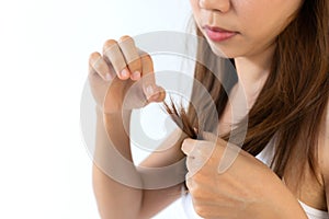 Close up of sad young Asian girl is looking at her damaged hair.  on white background