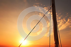 close-up of sailboat mast with setting sun in the background