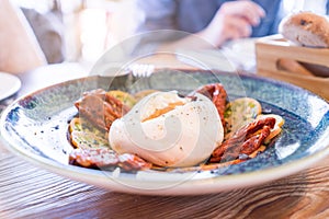 Close up of salad with burrata cheese, mozzarella and tomato with olive oil at restaurant