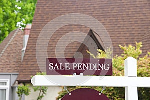 Close up of SALE PENDING sign in front of house photo