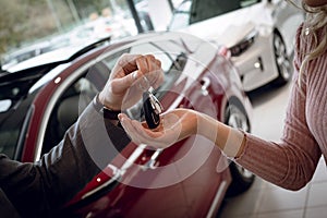 Close up of salesman giving car keys to female customer