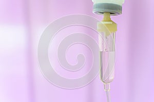 Close up saline IV drip for patient and Infusion pump in hospital with purple drape background..