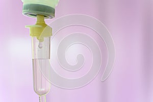 Close up saline IV drip for patient and Infusion pump in hospital with purple drape background..