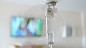 Close-up of saline solution drip for patient and infusion pump on blurred luxury vip room background in hospital.
