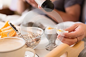 Close-up of salt shaker above soft boiled egg