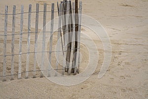 Close up of a sand dunes on a beach with wooden fence