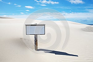 Sand dunes with empty warning sign