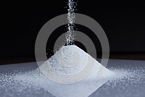 Close up of sand falling into a pile on black background