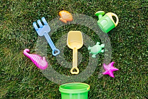 close up of sand toys kit on green lawn or grass