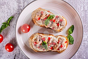 Close up of sandwiches with canned tuna, pepper and basil on cream cheese on a plate top view