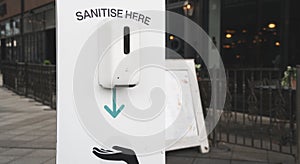 Close up of a Sanitise hands dispenser in a shopping centre photo