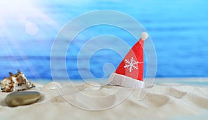 Close Up Santa Hat On A White Sandy Infinity Caribbean Beach . Christmas Holiday Travel Concept