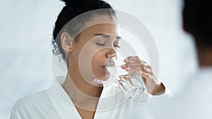 Close up satisfied beautiful African American woman drinking water