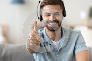 Close up satisfied man in headset showing thumbs up, approval