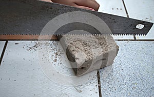 close up saws cutting concrete blocks placed on a ceramic tile background