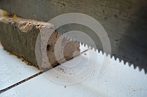 close up saws cutting concrete blocks placed on a white tile bac